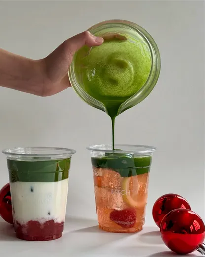 Usucha poured from a glass katakuchi into an ichigo latte and a strawberry honey lemon, red baubles alongside