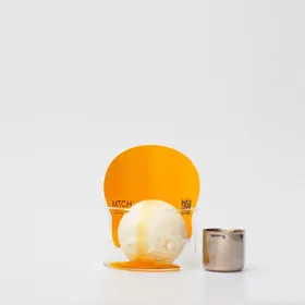 Yoghurt gelato in a glass under a disc of forest honey and yuzu
