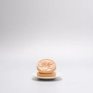 Sakura monaka on a small white plate, wafer shell stamped with a cherry blossom